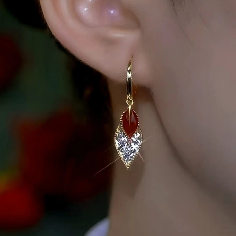 Model showcasing the dangle and style of the 14K Gold-Plated Red Oil Drop Diamond Double-Leaf Earrings