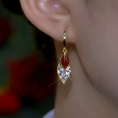 Model showcasing the dangle and style of the 14K Gold-Plated Red Oil Drop Diamond Double-Leaf Earrings
