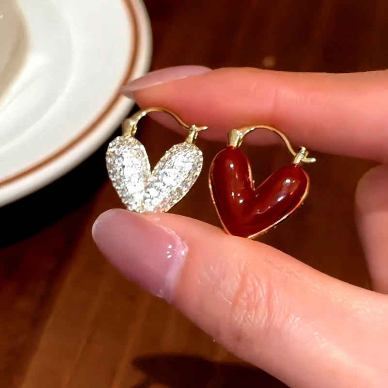 Model showcasing the dangle and style of the 14K Gold-Plated Red Oil Drop Diamond Heart Earrings