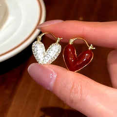 Model showcasing the dangle and style of the 14K Gold-Plated Red Oil Drop Diamond Heart Earrings