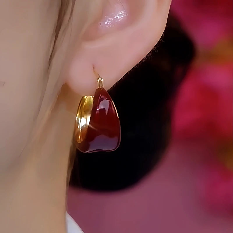 Model showcasing the dangle and style of the 14K Gold-Plated Red Oil Drop Earrings
