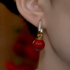 Model showcasing the dangle and style of the 14K Gold-Plated Red Pearl Earrings