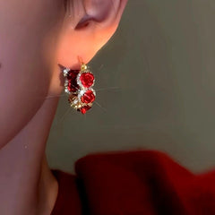 Model showcasing the dangle and style of the 14K Gold-Plated Red Rose Hoop Earrings