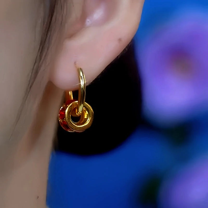 Model showcasing the dangle and style of the 14K Gold-Plated Red Zircon Diamond Hoop Earrings