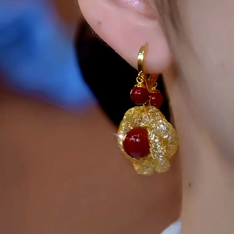 Model showcasing the dangle and style of the 14K Gold-Plated Retro Red Pearl Mesh Earrings