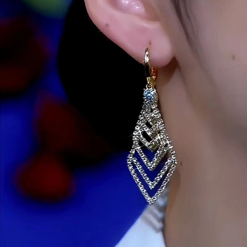 Model showcasing the dangle and style of the 14K Gold-Plated Rhinestone Geometric Earrings
