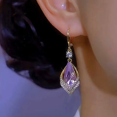 Model showcasing the dangle and style of the 14K Gold-Plated Rhombus Purple Crystal Earrings