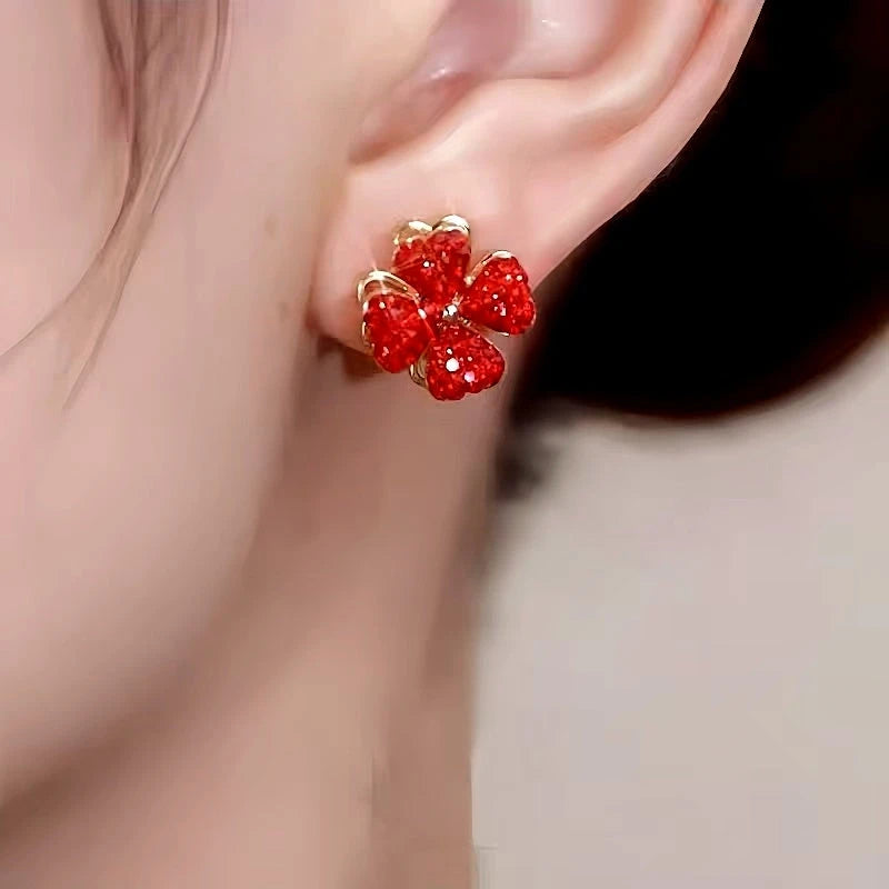 Model showcasing the dangle and style of the 14K Gold-Plated Rotating Red Flower Earrings