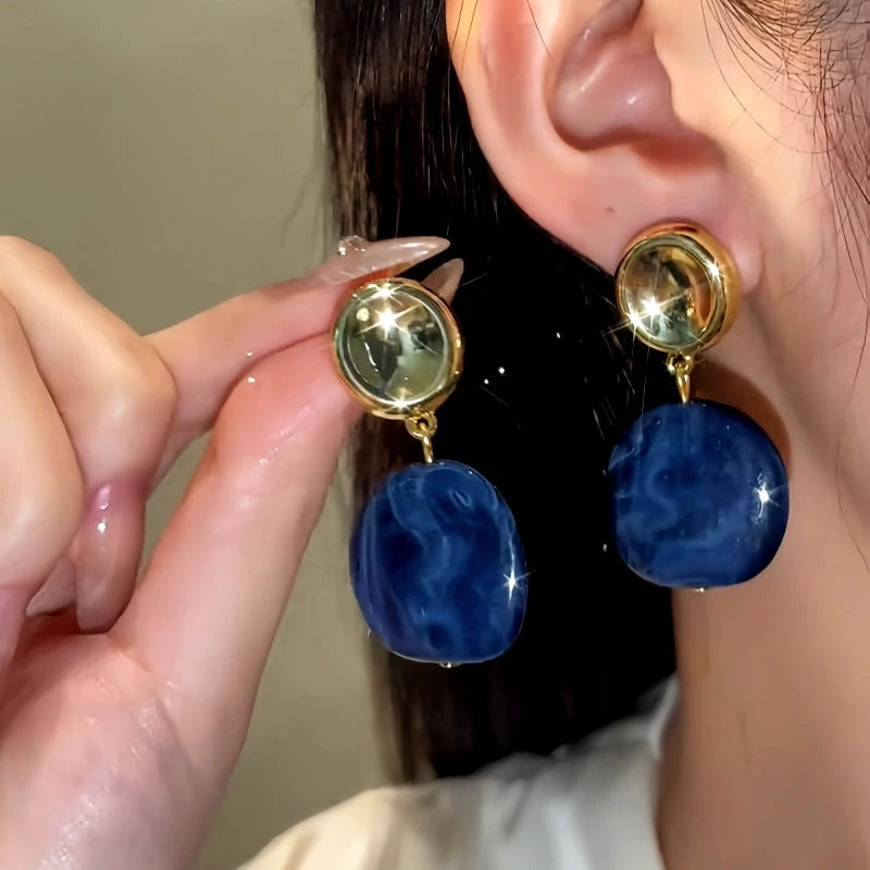 Model showcasing the dangle and style of the 14K Gold-Plated Round Geometric Irregular Earrings