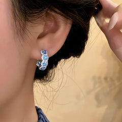 Model showcasing the dangle and style of the 14K Gold-Plated Sea Blue Zircon Diamond Hoop Earrings