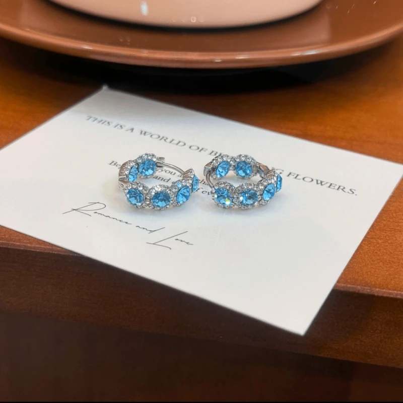 Angled view of the 14K Gold-Plated Sea Blue Zircon Diamond Hoop Earrings