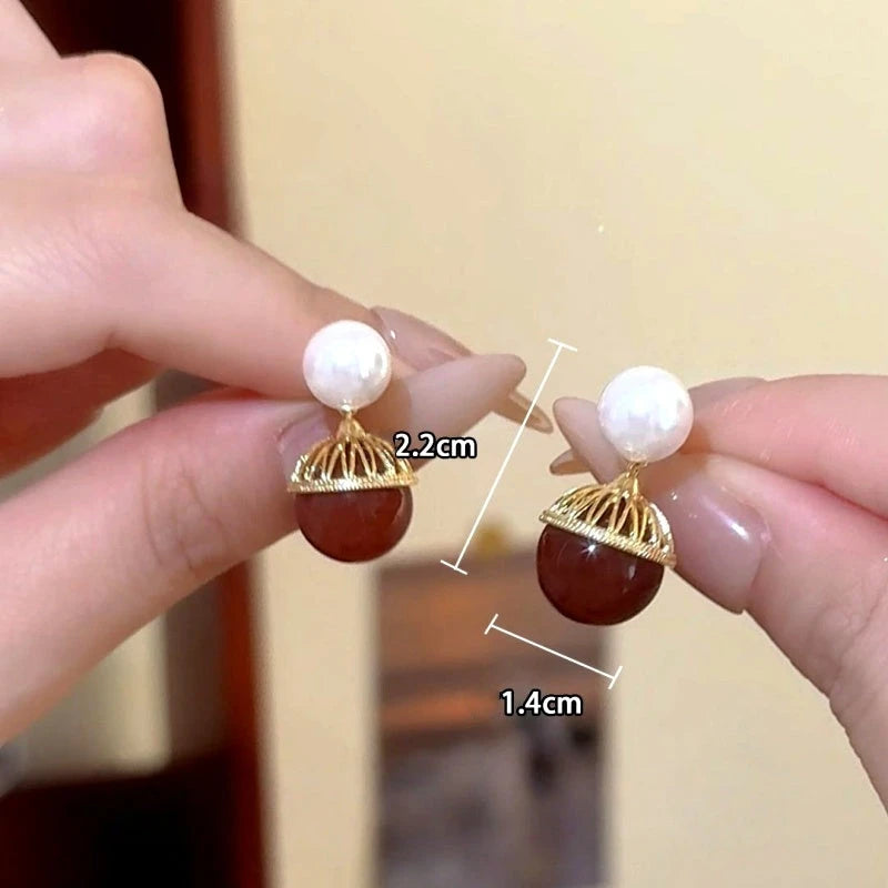 Angled view of the 14K Gold-Plated Shell Shadow Pearl Earrings