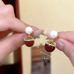 Angled view of the 14K Gold-Plated Shell Shadow Pearl Earrings