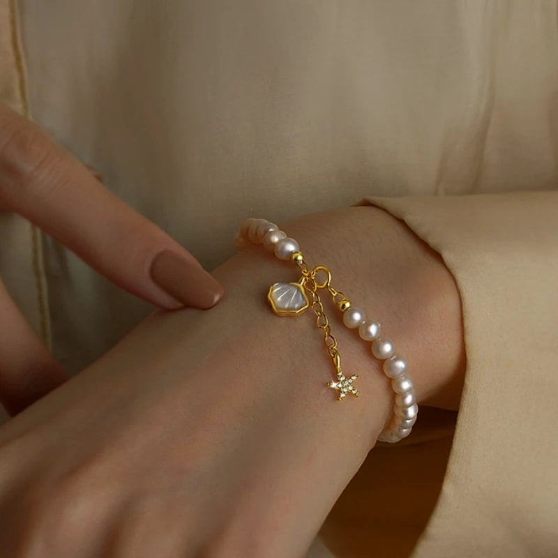 Model wearing the 14K Gold-Plated Shell Starfish Pearl Bracelets to highlight its design on the wrist