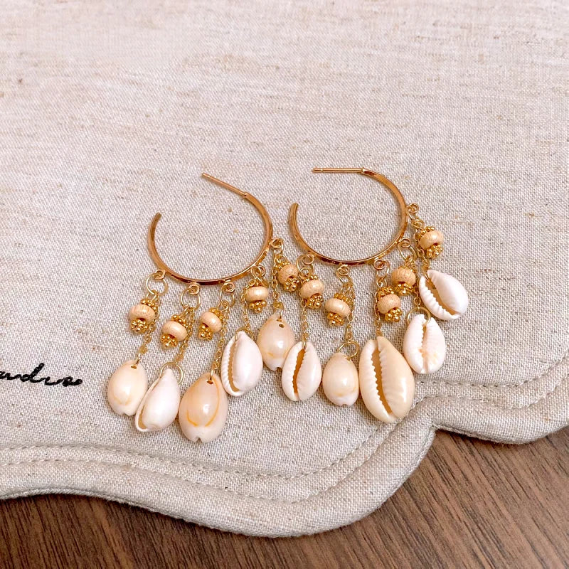 Model showcasing the dangle and style of the 14K Gold-Plated Shell Tassel Earrings