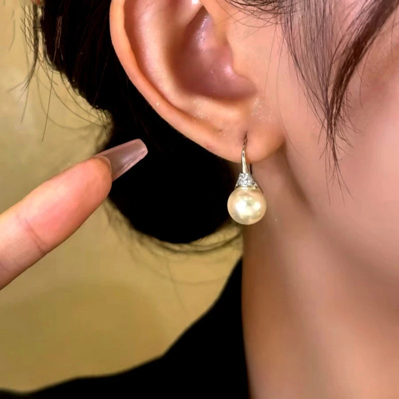 Model showcasing the dangle and style of the 14K Gold-Plated Simple And Versatile Pearl Earrings