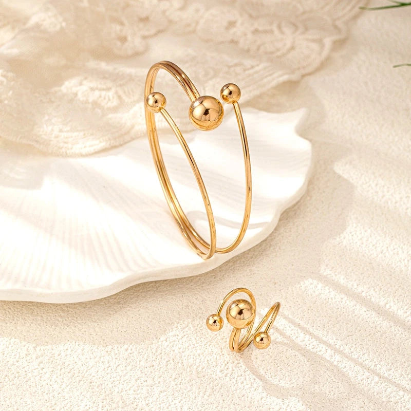 Model wearing the 14K Gold-Plated Simple Ball Bracelet And Ring Set to highlight its design on the wrist