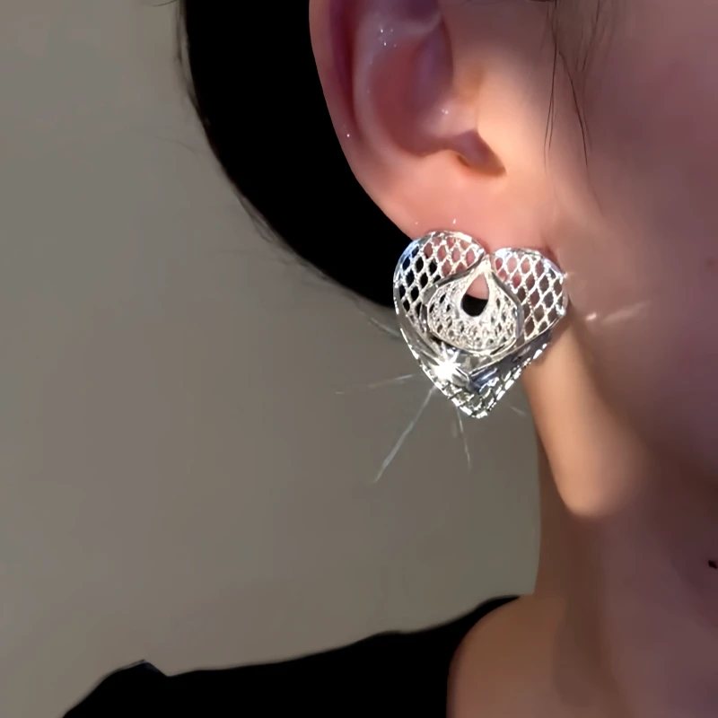 Model showcasing the dangle and style of the 14K Gold-Plated Simple Heart Design Earrings