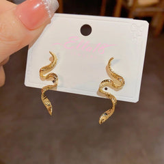 Pair of gold twisted snake drop earrings on jewelry display card