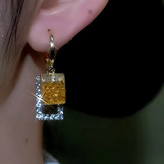 Model showcasing the dangle and style of the 14K Gold-Plated Square Crystal Earrings