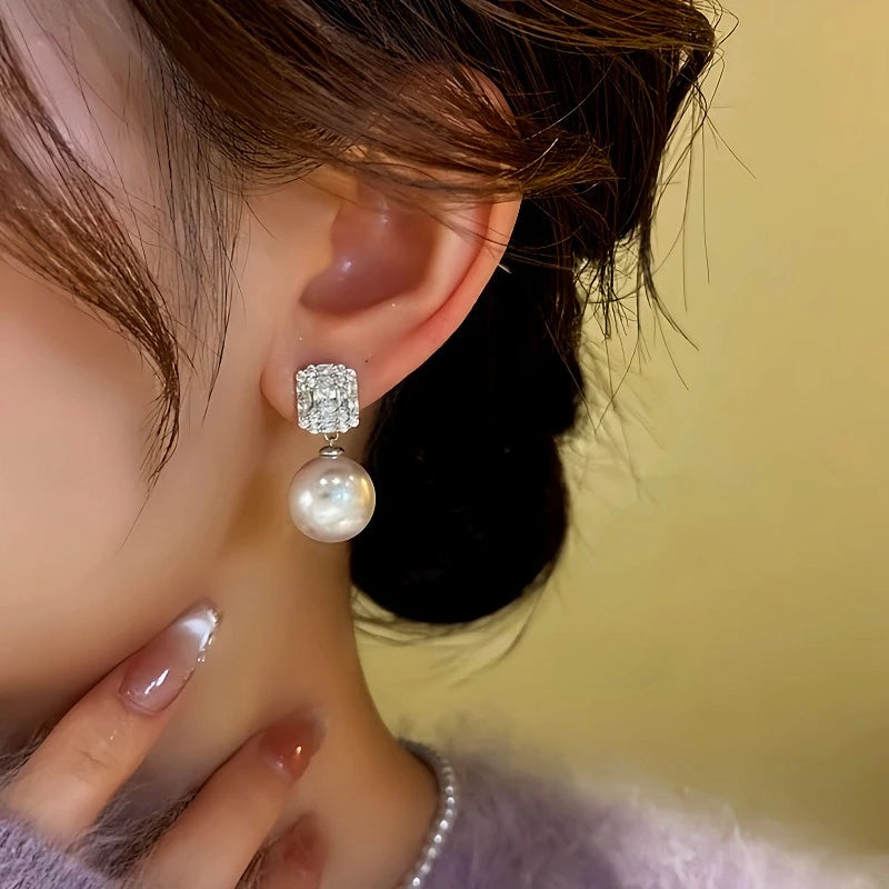 Model showcasing the dangle and style of the 14K Gold-Plated Square Zircon Bead Earrings
