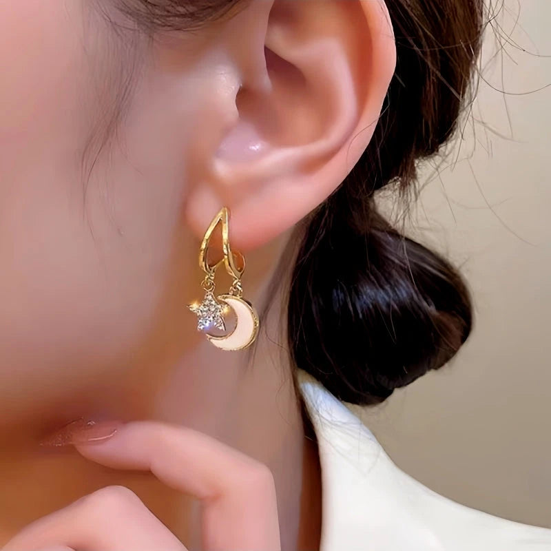 Model showcasing the dangle and style of the 14K Gold-Plated Star And Moon Earrings