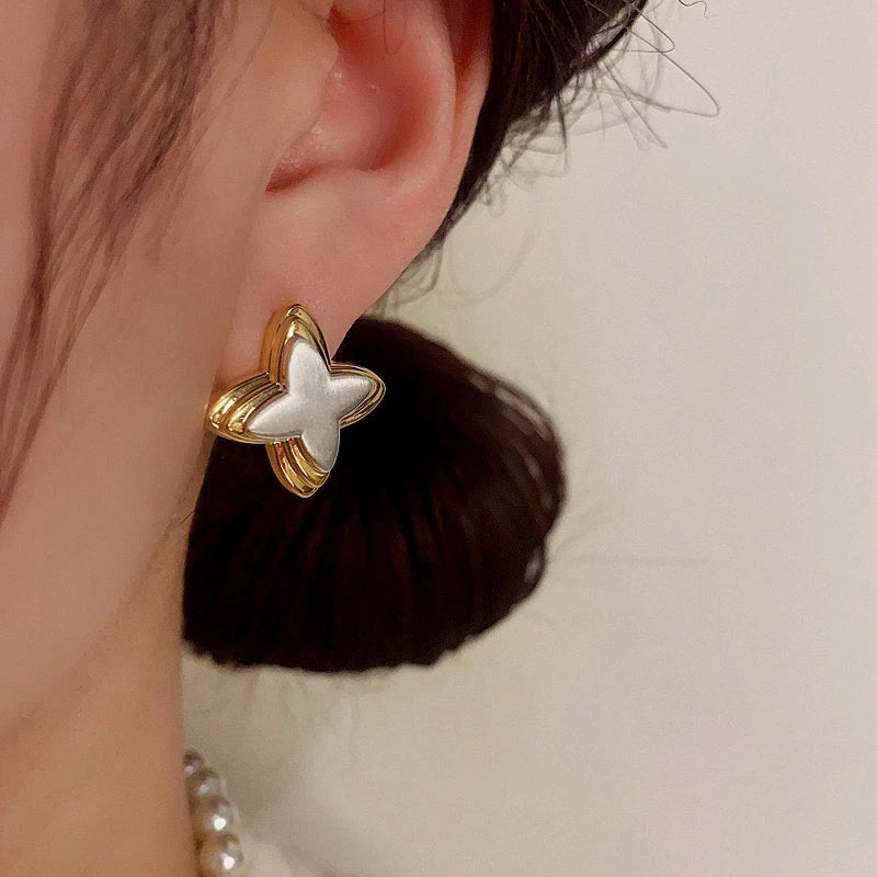 Model showcasing the dangle and style of the 14K Gold-Plated Star Stud Earrings