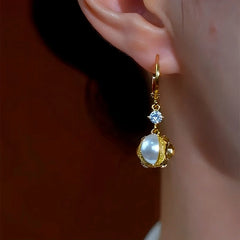 Model showcasing the dangle and style of the 14K Gold-Plated Stone Pearl Earrings