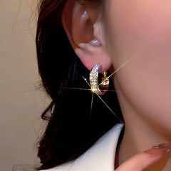 Model showcasing the dangle and style of the 14K Gold-Plated Super-Shiny Rhinestone Hoop Earrings