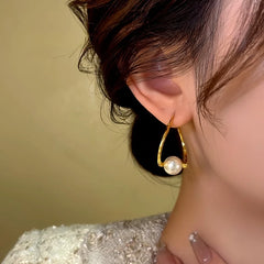 Model showcasing the dangle and style of the 14K Gold-Plated Temperamental Irregular Twisted Pearl Earrings