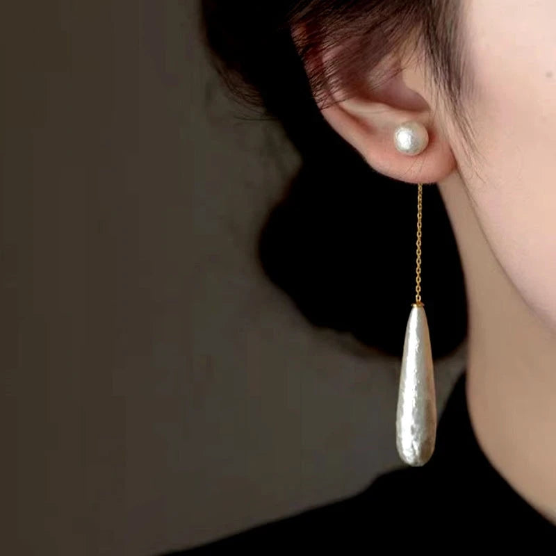 Model showcasing the dangle and style of the 14K Gold-Plated Textured Water Drop Pearl Earrings