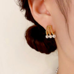 Model showcasing the dangle and style of the 14K Gold-Plated Three-Row Hollow Pearl Earrings