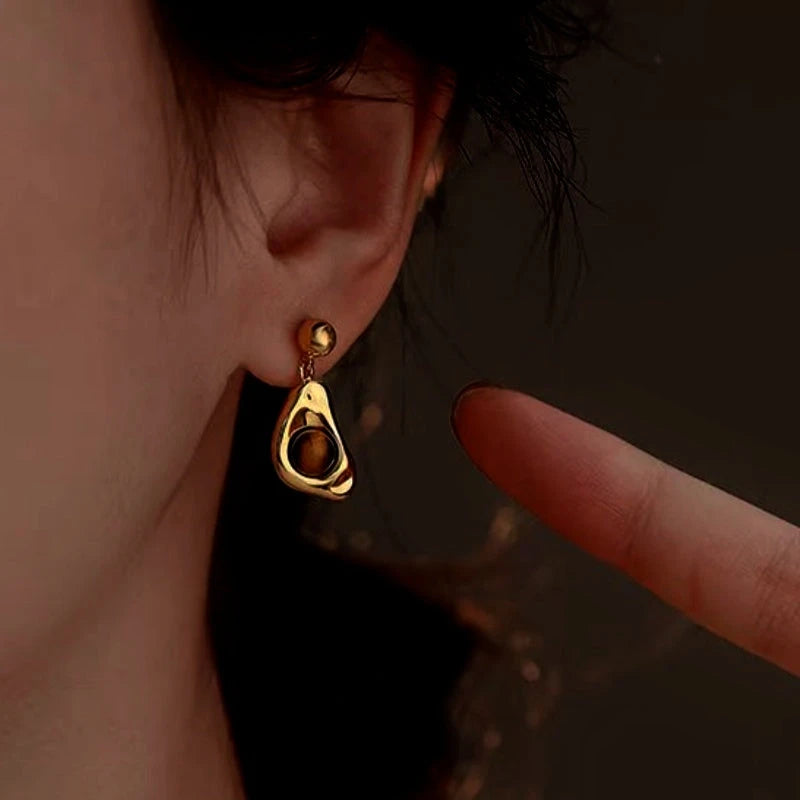 Model showcasing the dangle and style of the 14K Gold-Plated Tiger Eye Stone Earrings