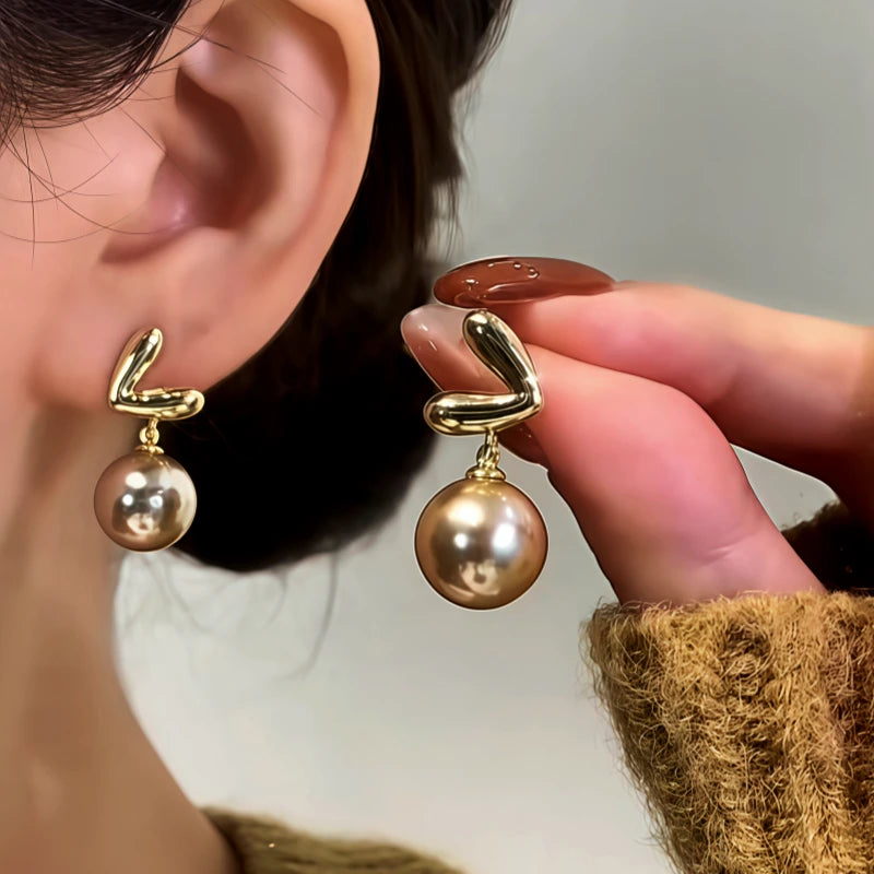 Angled view of the 14K Gold-Plated Trendy Heart Pearl Earrings