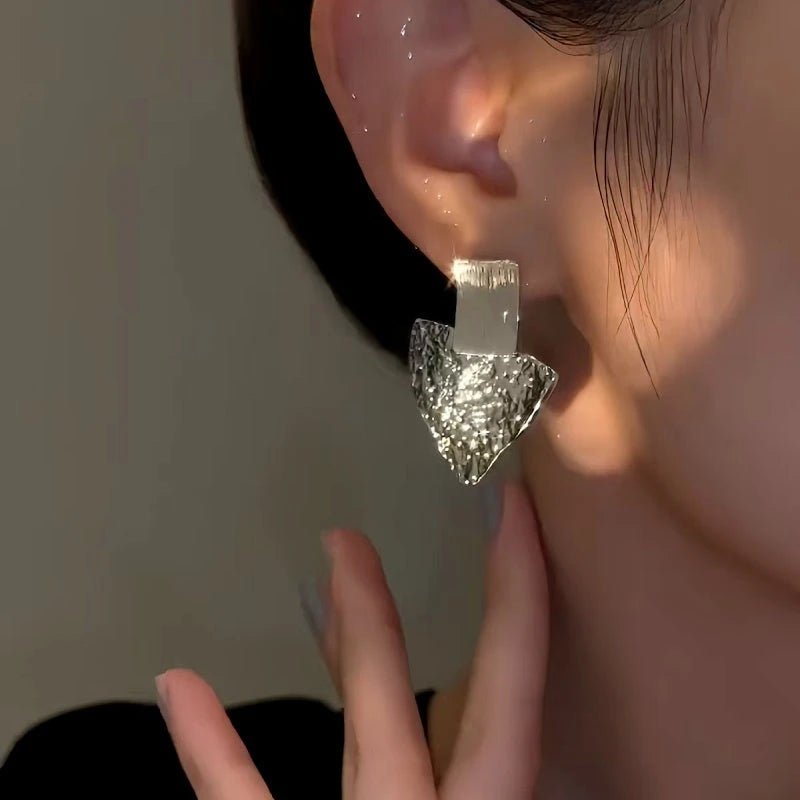 Model showcasing the dangle and style of the 14K Gold-Plated Triangle Earrings