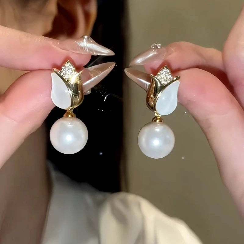 Model showcasing the dangle and style of the 14K Gold-Plated Tulip Pearl Earrings And Necklace Set