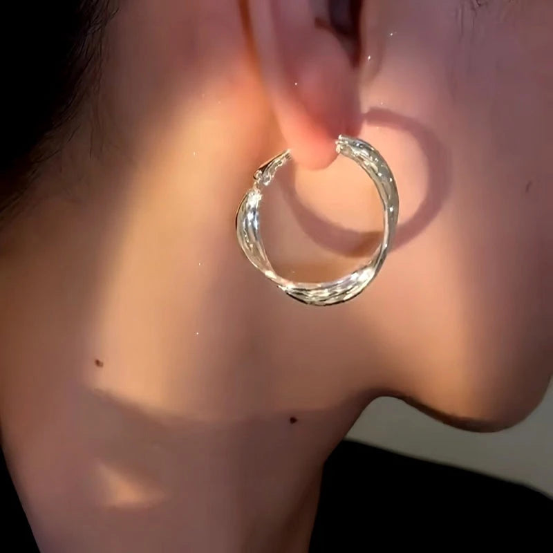 Model showcasing the dangle and style of the 14K Gold-Plated Twist Hoop Earring