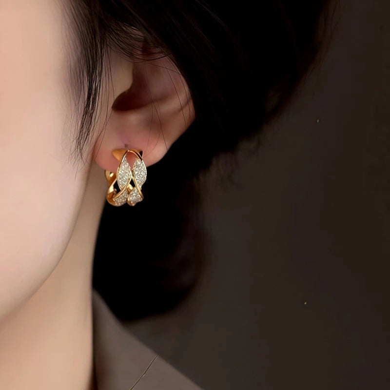 Model showcasing the dangle and style of the 14K Gold-Plated Twisted Diamond C Hoop Earrings