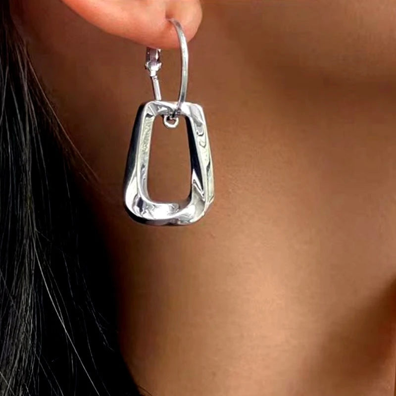 Model showcasing the dangle and style of the 14K Gold-Plated Twisted Earrings