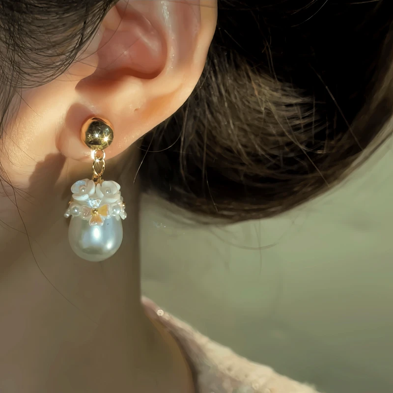 Model showcasing the dangle and style of the 14K Gold-Plated Water Drop Flower Pearl Earrings