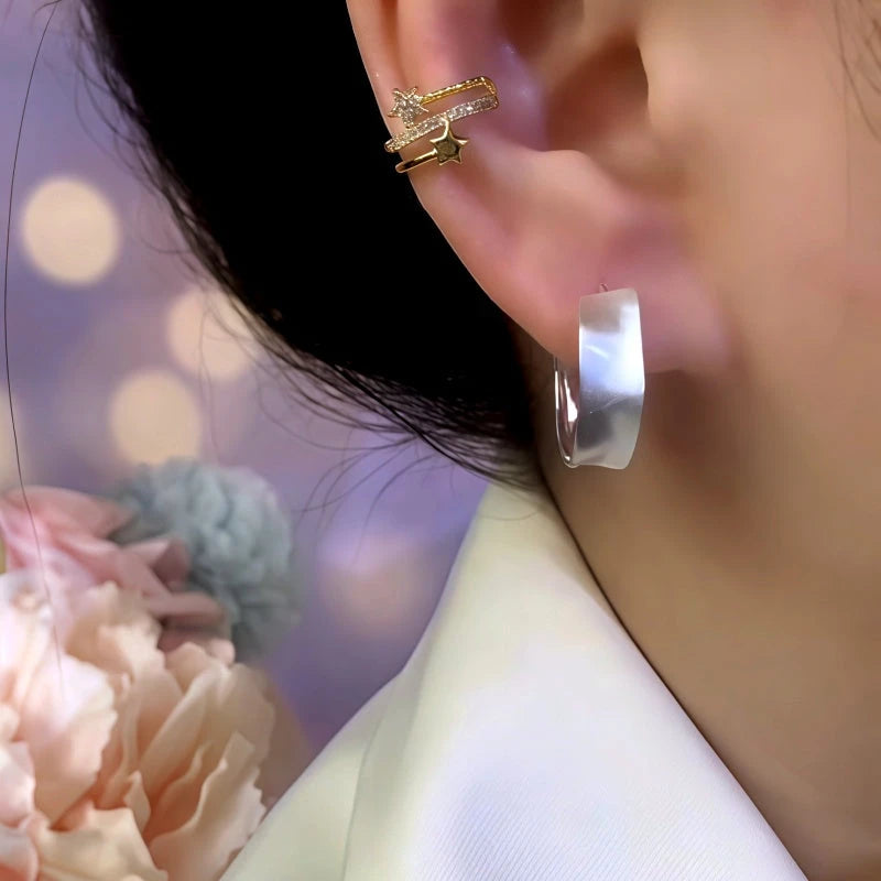 Model showcasing the dangle and style of the 14K Gold-Plated Wavy Hoop Earrings