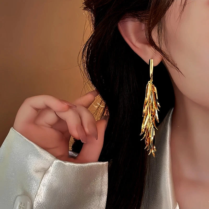 Model showcasing the dangle and style of the 14K Gold-Plated Wheat Tassel Earrings
