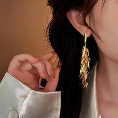 Model showcasing the dangle and style of the 14K Gold-Plated Wheat Tassel Earrings