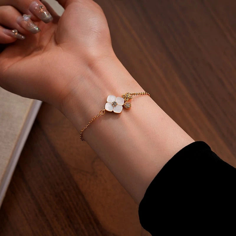 Model wearing the 14K Gold-Plated White Mother-Of-Pearl Four-Leaf Clover Bracelet to highlight its design on the wrist