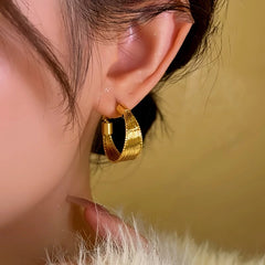 Model showcasing the dangle and style of the 14K Gold-Plated Wire Wrapped Earrings