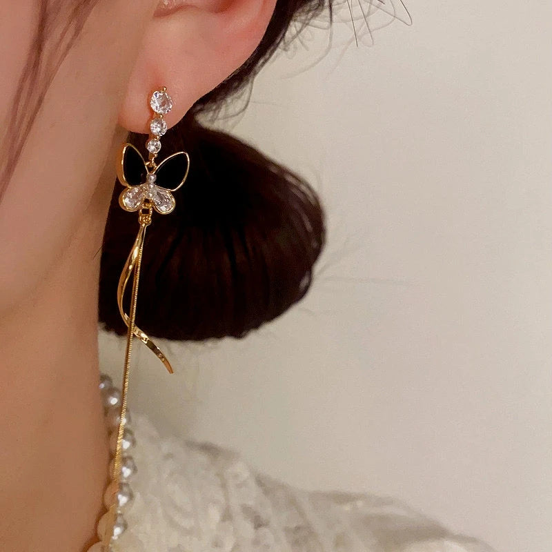 Model showcasing the dangle and style of the 14K Gold-Plated ZIrcon Butterfly Tassel Earrings