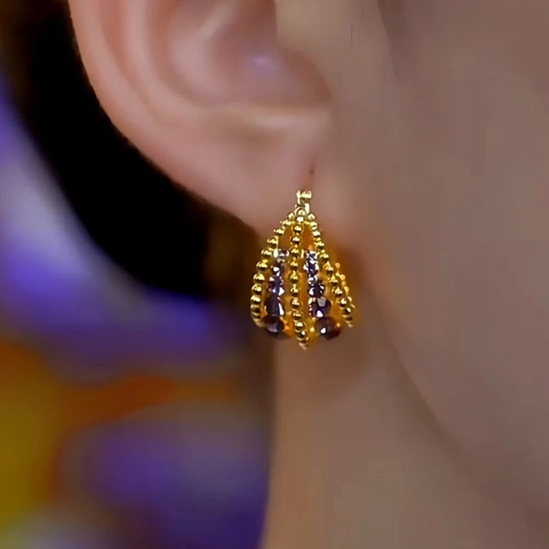 Model showcasing the dangle and style of the 14K Gold-Plated Zircon Basket Earrings