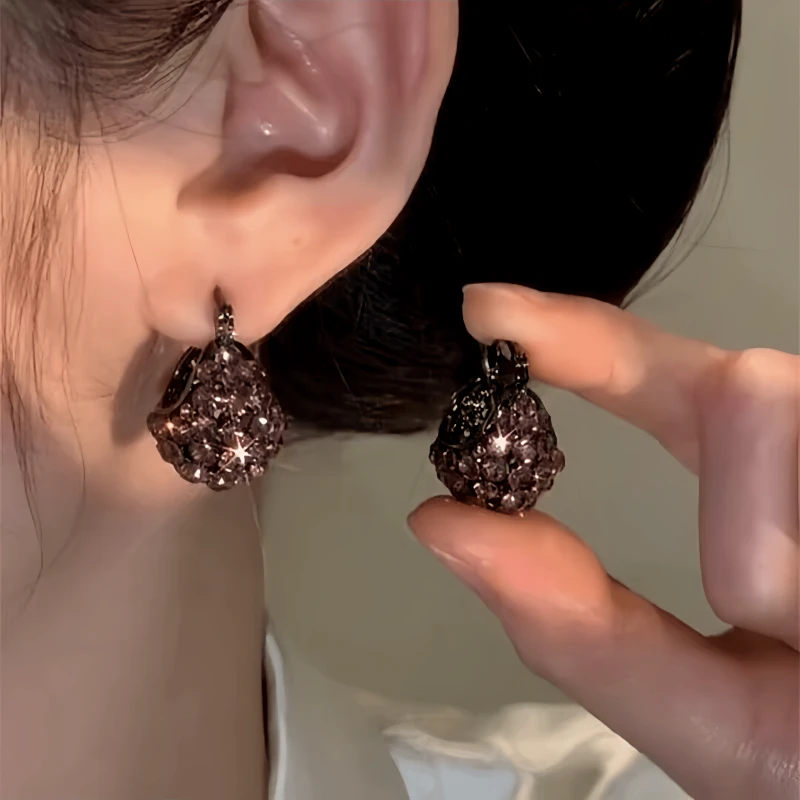 Model showcasing the dangle and style of the 14K Gold-Plated Zircon Basket Earrings