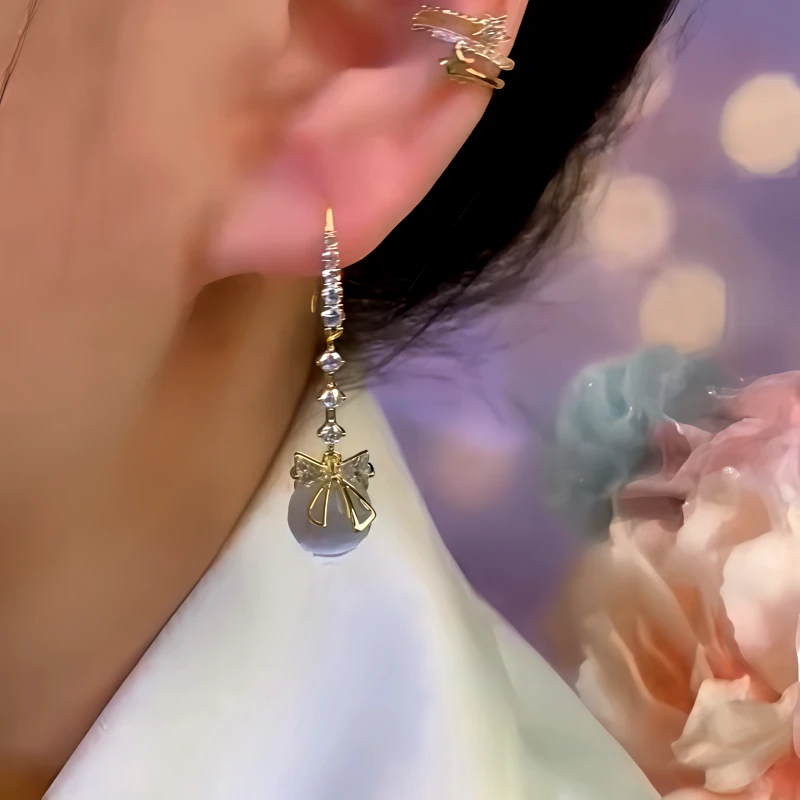Model showcasing the dangle and style of the 14K Gold-Plated Zircon Bead Bow Ear Hook Earrings