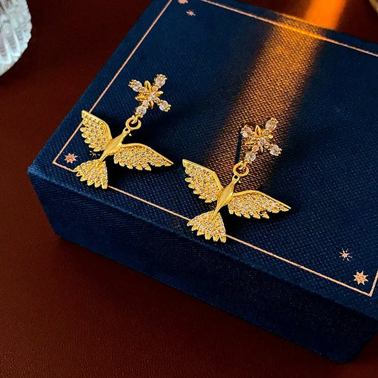 Model showcasing the dangle and style of the 14K Gold-Plated Zircon Bird Earrings
